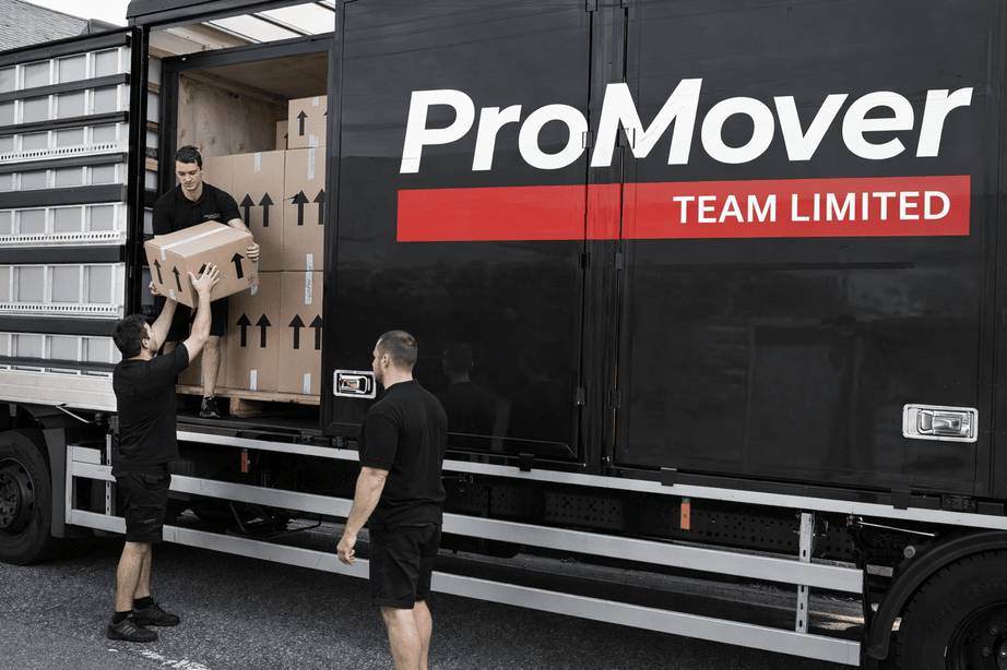 Removals team loading boxes into large moving truck for house move in London